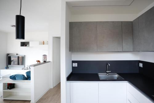 a kitchen with white cabinets and a sink at IseoLakeRental - Monti e Lago in Solto Collina