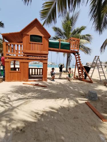 a playground on the beach with two children playing at شاليه الحمرا 2-12بدرة العروس in Jeddah