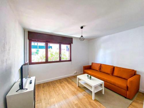 - un salon avec un canapé orange et une télévision dans l'établissement Appartement 1 chambre proche plages, à Toulon