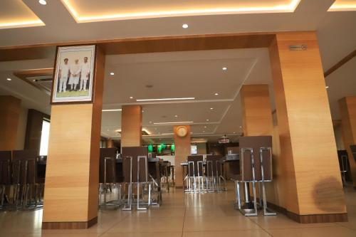 a lobby with chairs and tables in a building at Hotel JD in Surat