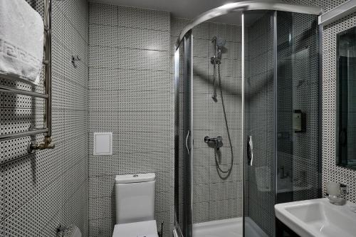 a bathroom with a shower and a toilet and a sink at Goral Hotel & Spa in Bukovel
