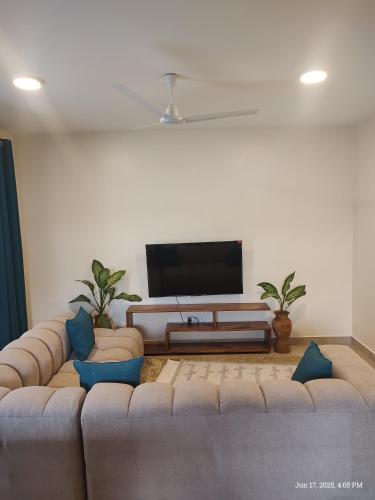 a living room with a large couch and a flat screen tv at Casa Nampala 2bedrom units in Ukunda