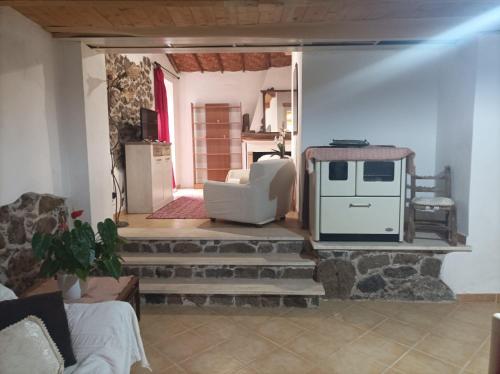 ein Wohnzimmer mit einem weißen Stuhl und einem Herd in der Unterkunft Domus Maria in Milis