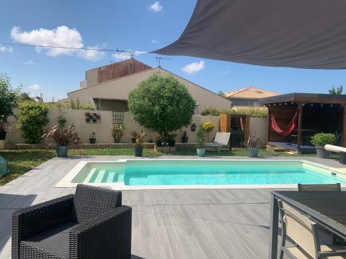 une piscine avec deux chaises et une maison dans l'établissement La petite Clavette, à Clavette