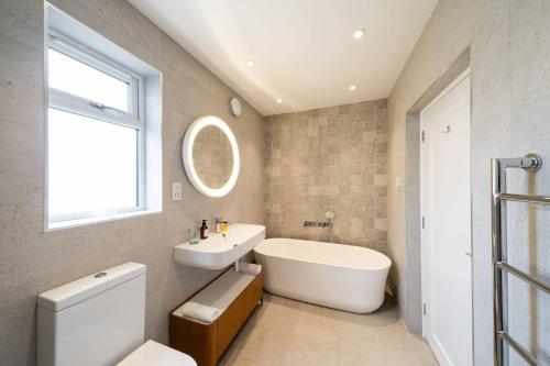 a bathroom with a sink and a tub and a toilet at Newhall Gardens in Invergowrie