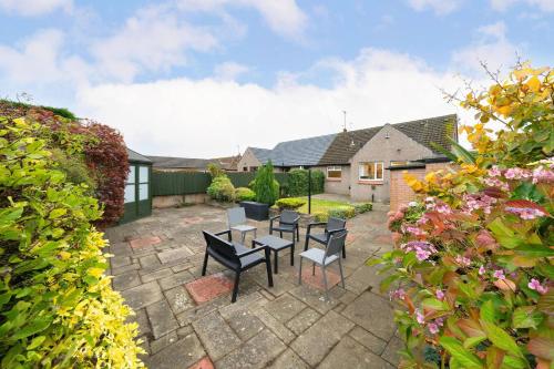 a patio with chairs and a table in a yard at Taigh Tatha in Broughty Ferry
