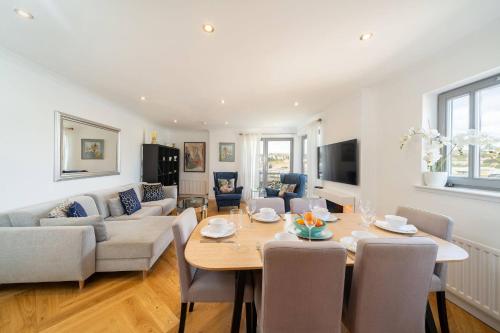 a dining room and living room with a table and chairs at Twin Bridges in Dundee