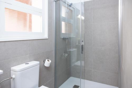 a bathroom with a glass shower with a toilet at RVApartaments Escala Brava in L'Escala