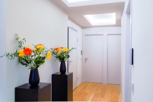 a hallway with two vases with flowers in it at Virginia Madre Luxury Rooms in San Benedetto del Tronto