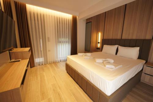 a bedroom with a large bed and a flat screen tv at Sunrise Luxury Apartments in Fanárion