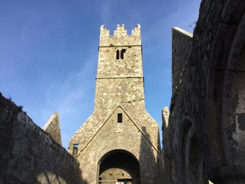 a large stone building with a tower on top at Ryan's River Lodge B&B in Cong