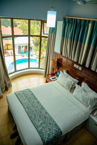 a bedroom with a bed with a view of a pool at Green Mountain Hotel in Arusha