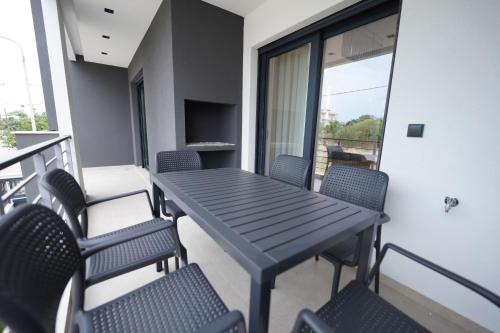 a table and chairs on a balcony with a television at Sunrise Luxury Apartments in Fanárion