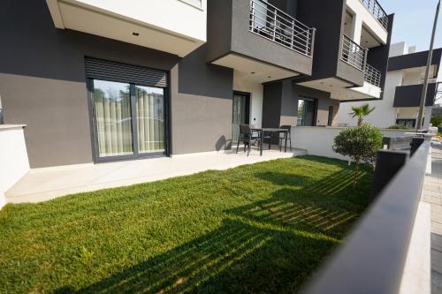 a house with a green lawn in front of it at Sunrise Luxury Apartments in Fanárion