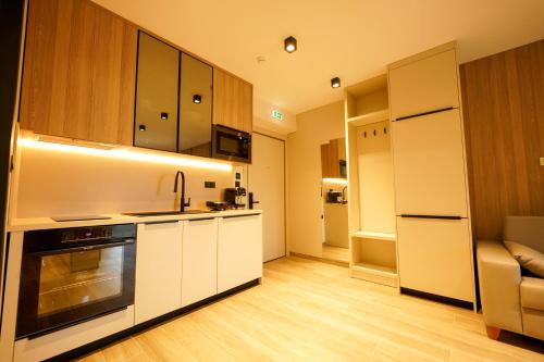 a kitchen with white cabinets and a sink and a stove at Sunrise Luxury Apartments in Fanárion