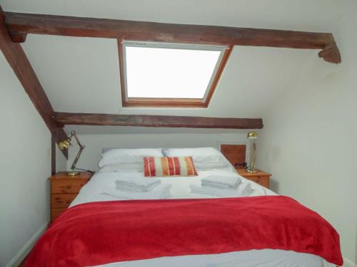 a bedroom with a bed with a red blanket at Emily's View, Ireby in Ireby
