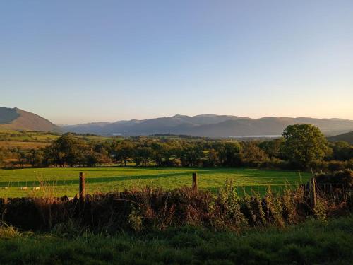 a fence in a field with mountains in the background at Emily's View, Ireby in Ireby