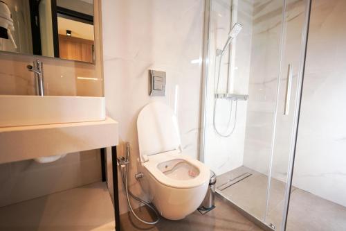 a bathroom with a toilet and a glass shower at Sunrise Luxury Apartments in Fanárion