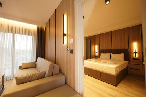 a bedroom with a bed and a chair and a window at Sunrise Luxury Apartments in Fanárion