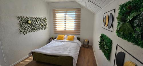 a small bedroom with a bed with yellow pillows at Vikendica Iris in Laktaši