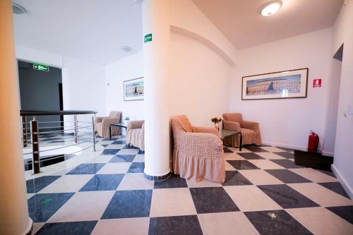 a lobby with a checkered floor and chairs at Visconti Militari in Bucharest