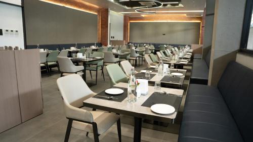 a dining room with tables and chairs and a chalkboard at Zip By Spree Hotels Chinchwad in Chinchiwad