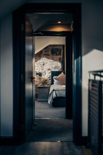 a view of a bedroom with a bed through a doorway at The Stables in Dundee