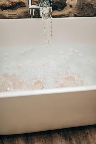 a bath tub with water coming out of it at The Stables in Dundee