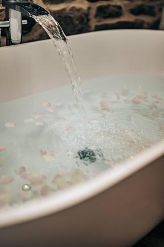 a bath tub with water coming out of it at The Stables in Dundee