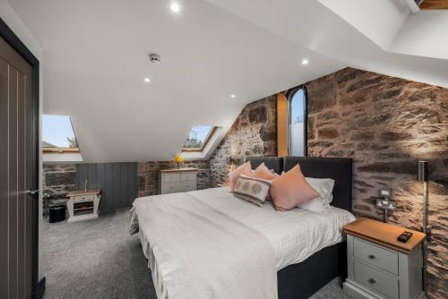 a bedroom with a bed and a stone wall at The Stables in Dundee