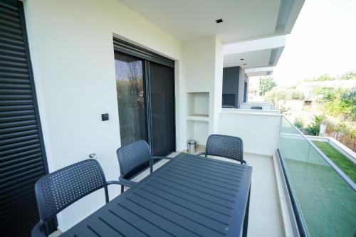 a balcony with two chairs and a table and a window at Sunrise Luxury Apartments in Fanárion