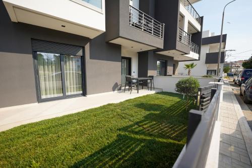 a house with a green lawn in front of it at Sunrise Luxury Apartments in Fanárion