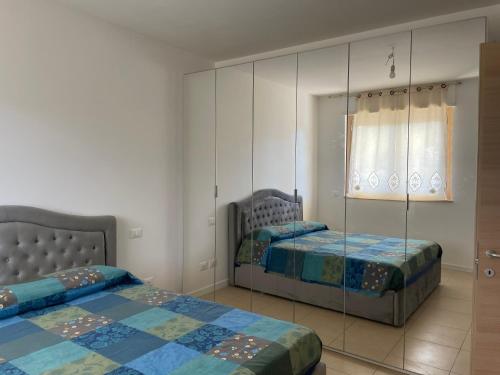 a bedroom with two beds and a mirror at Casa Junea in Maccarese