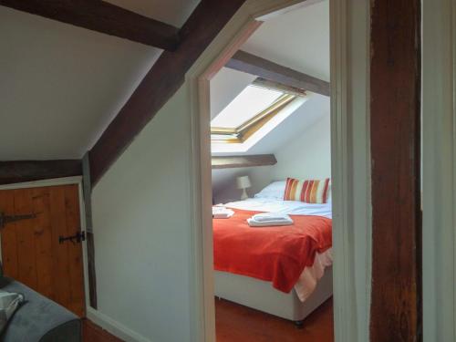 a bedroom with a bed with a red blanket at Emily's Apartment, Ireby in Ireby
