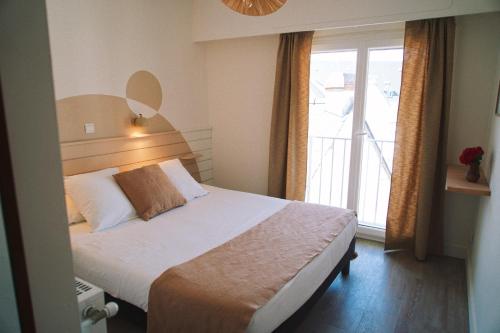 Ένα ή περισσότερα κρεβάτια σε δωμάτιο στο Hôtel Dune Saint-Pierre