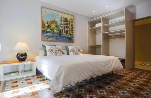 バルセロナにあるプロベンサ フラットのベッドルーム(白い大型ベッド1台、絵画付)