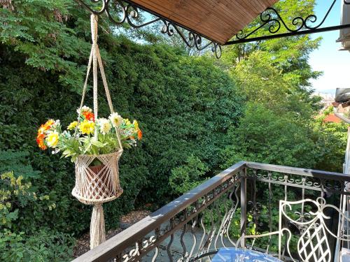 a basket of flowers is hanging on a balcony at Vila Eden Boutique Hotel in Korçë