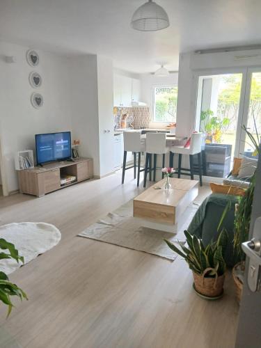 un salon avec un canapé et une table dans l'établissement Appartement cosy à Caen avec terrasse et jardin, à Caen