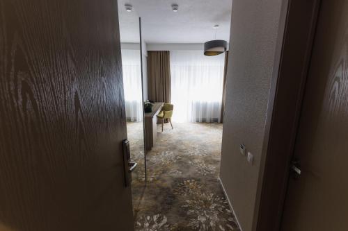 an open door to a room with a table at Nedei Hotel&Spa Transalpina in Martinie