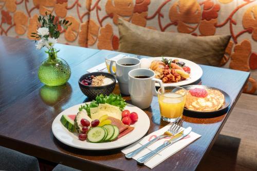 a table with plates of food and drinks on it at Original Sokos Hotel Albert in Helsinki