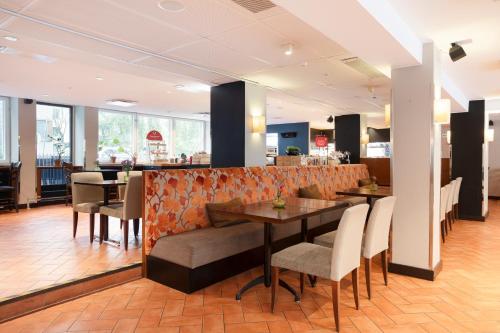 a restaurant with a table and chairs and a bar at Original Sokos Hotel Albert in Helsinki
