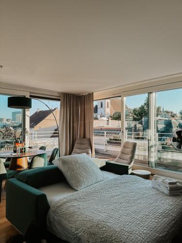 a bedroom with a bed and a large window at Just Sunny - Rooftop mitten in der Stadt in Basel