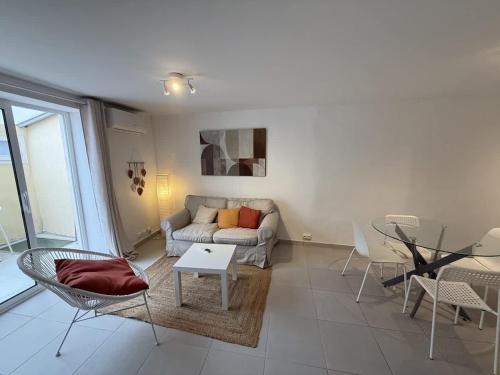 un salon avec un canapé, une table et des chaises dans l'établissement Le Faience Appart Cosy & central, à Béziers