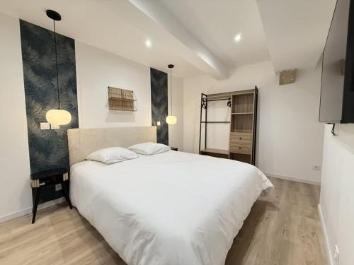 une chambre avec un grand lit blanc avec deux oreillers dans l'établissement Le Faience Studio Cocon chic au coeur de Beziers, à Béziers