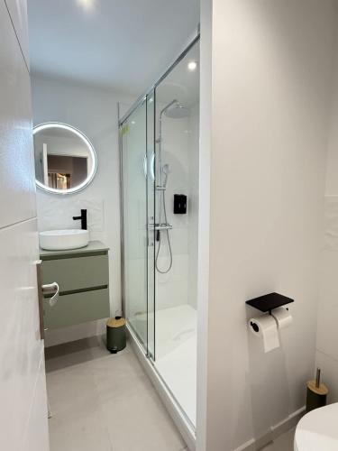 une salle de bain blanche avec une douche et un lavabo dans l'établissement Le Faience Studio Cocon chic au coeur de Beziers, à Béziers