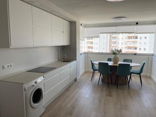 a kitchen with a table and chairs and a laundry machine at Mi casa vacacional en Valdelagrana in El Puerto de Santa María