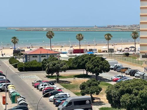 a parking lot with parked cars and the beach at Mi casa vacacional en Valdelagrana in El Puerto de Santa María