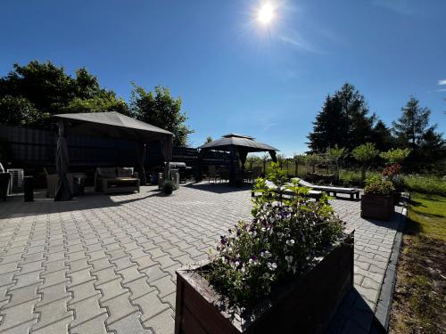 a patio with tables and umbrellas and flowers at Do Brzegu Lepiej - Siedlisko Jemiołowo - Apartamenty Blisko Jeziora II in Olsztynek