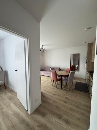 a living room with a table and chairs and a mirror at Apartament Varsovia Residence in Elblag
