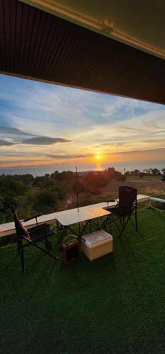a patio with a table and a chair and the sunset at Duview room in Nong Prue